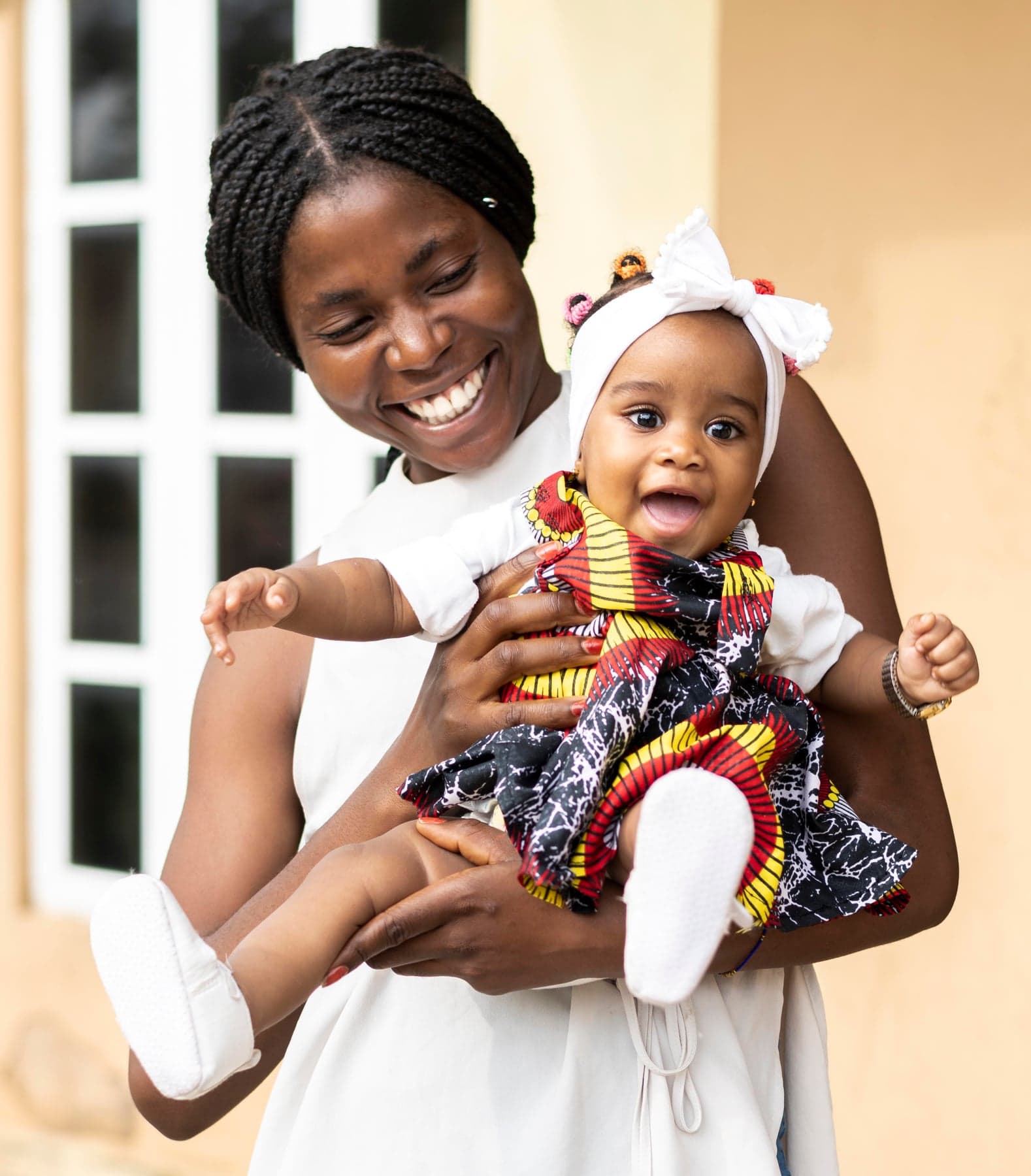 A vetted Taskbed nanny holding a happy little girl